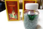 Dwa kartoniki oraz przeźroczyste opakowanie z zielonymi podłużnymi tabletkami, zawierające preparat z pławikonika