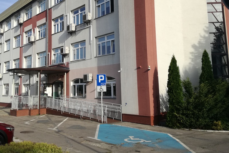 Drzwi budynku usytuowane są na wysokości około  50 cm od poziomu chodnika, do których prowadzą schody wykonane z płytki antypoślizgowej. Dojście do drzwi wejściowych wyposażone jest w specjalnie wyprofilowany podjazd wejście/wjazd od strony prawej dla osób niepełnosprawnych.