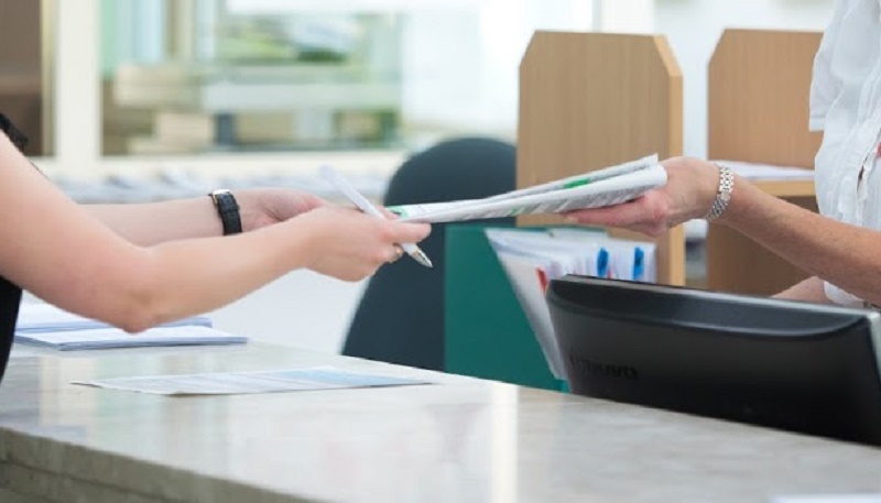 Na zdjęciu osoby przekazują sobie dokumenty