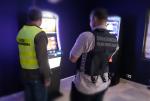 funkcjonariusze Służby Celno- Skarbowej i Straży Granicznej stoją przed automatem do gier