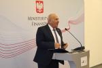 Minister Tadeusz Kościński przemawia przy mównicy na tle banera MF