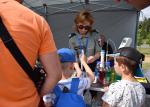 Funkcjonariuszka przeprowadza pokaz eksperymentu dla stojących dzieci