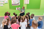 Funkcjonariuszka pokazuje dzieciom ilustracje w książce