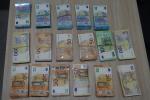 Pliki banknotów o nominałach 20, 50, 100 i 200 euro, spięte gumkami i poukładane na blacie