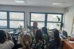 Grupa uczniów słucha wykładu prowadzonego przez funkcjonariuszkę KAS w Laboratorium Celno-Skarbowym