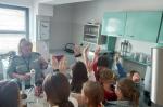 Grupa uczniów słucha wykładu prowadzonego przez funkcjonariuszkę KAS w Laboratorium Celno-Skarbowym