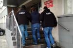 Funkcjonariusze CBŚP wprowadzają osobę zatrzymaną do budynku prokuratury, wchodzą po schodach