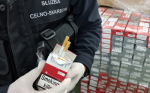 zdjęcie ilustracyjne- funkcjonariusz Służby Celno- Skarbowej przy zatrzymanych papierosach