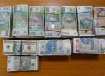 Pliki banknotów o nominałach 20, 50 i 100 PLN oraz 100 USD i 10 GBP spięte gumkami