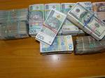 Pliki banknotów o nominałach 20, 50 i 100 PLN oraz 100 USD i 10 GBP spięte gumkami w innym ułożeniu