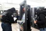 Funkcjonariusze służby celno-skarbowej stoją obok automatu do gier. W tle widać kolejne automaty