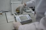 pracownik laboratorium celno-skarbowego wykonuje badanie  substancji za pomocą urządzenia