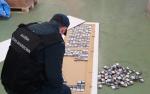 funkcjonariusz wyjmuje papierosy ze skrytek w panelach